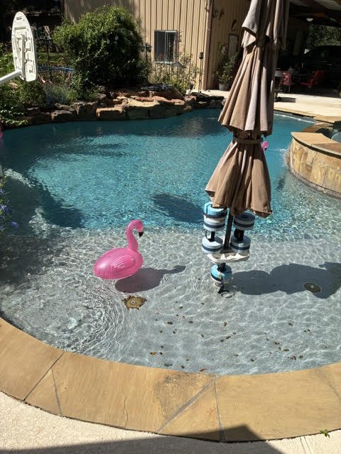 Before: debris on the pool floor near the umbrella stand